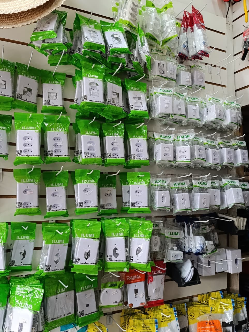 Tomadas, interruptores e placas expostos na parede da VHB Ferragem